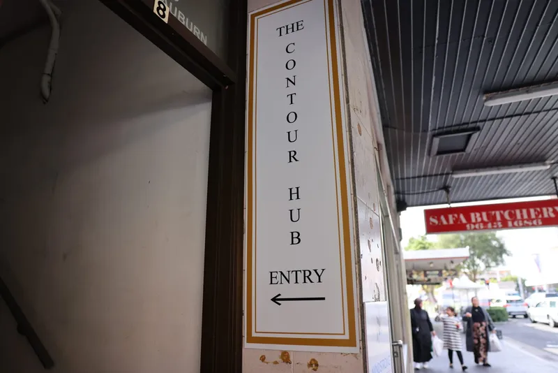 The Contour Hub’s vertical entry sign on Civic Road, with an arrow pointing towards the staircase to the clinic.